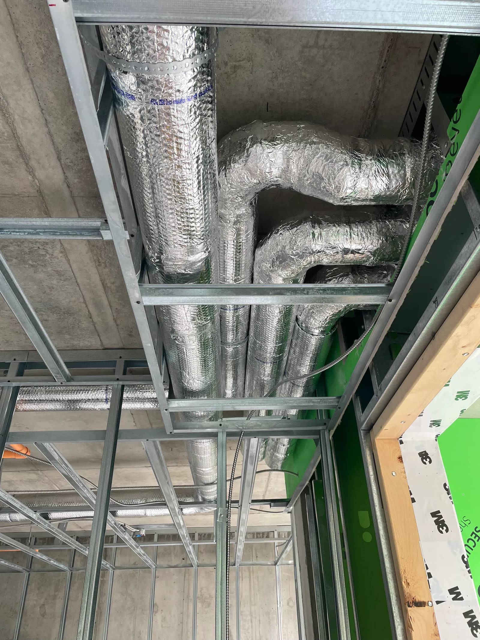Insulated flexible duct tied into rigid sheet metal takeoffs in a commercial ceiling