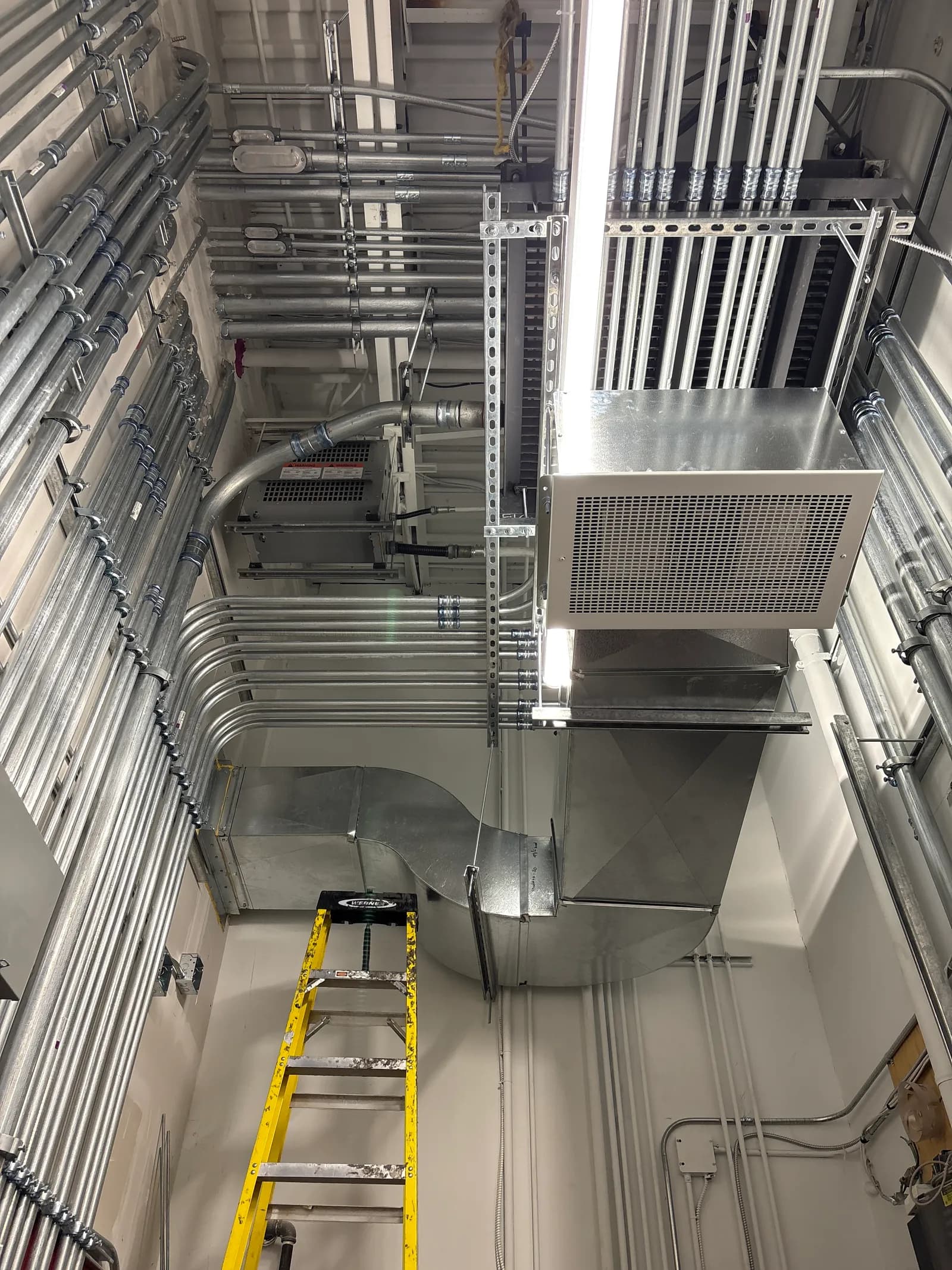 Rectangular galvanized ductwork transition and unit heater in a mechanical room